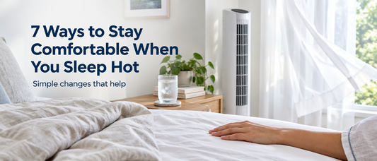 Peaceful bedroom with linen bedding, a glass of water and a quiet fan, with the text 7 Ways to Stay Comfortable When You Sleep Hot